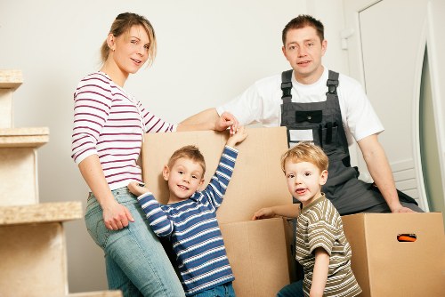 Removal team carrying furniture through a Catford townhouse hallway