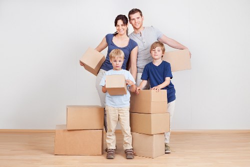Professional movers unloading furniture at a Catford property entrance